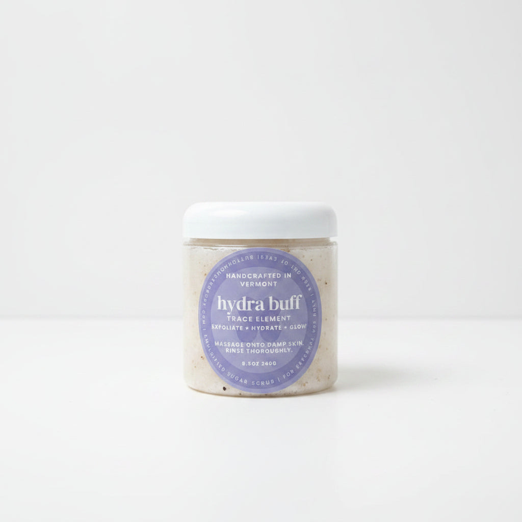 Jar of 'hydra buff' on a marble surface with greenery in the background