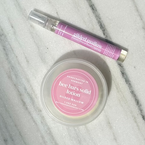 Solid lotion bar and perfume bottle on a marble surface