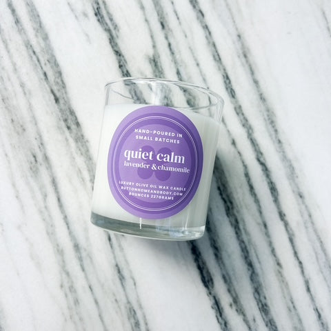 Candle with a purple label on a marble surface