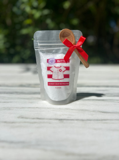 Image of 5 ounce product on a marble table with a cute, mini wooden spoon and red bow. Mini Spoon is gift with purchase and attached with a red bow.