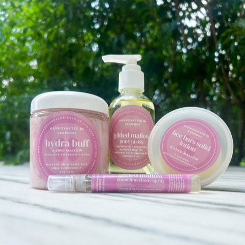 Set of skincare products with pink labels on a white surface with greenery in the background
