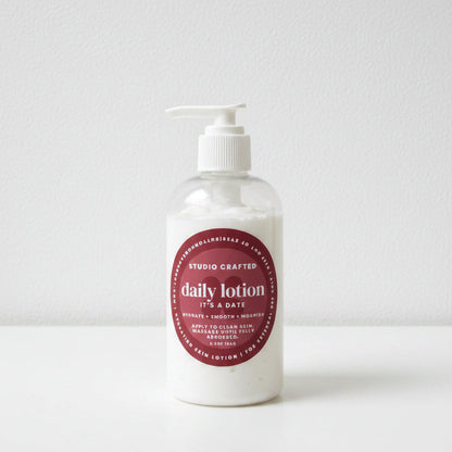 Bottle of daily lotion with a white pump  in a sticky warm fragrance button home and body 