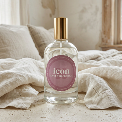 Icon room and linen spray on pale stone beside textured ivory bedding.