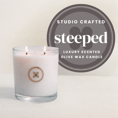 Luxury scented olive wax candle with 'Studio Crafted Day Spa' branding on a light green background